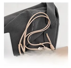 Close-up of beige lychee leather tote bag with elegant heart pattern silk scarf on strap