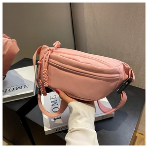Detailed shot of pink nylon waist bag featuring woven zip pullers and adjustable strap