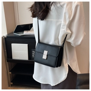 Detail of minimalist black leather crossbody bag with silver metallic square buckle
