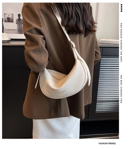 Close-up of white lychee texture crescent bag worn with a brown blazer for workwear style
