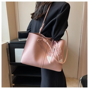 Pink lychee leather tote bag with decorative scarf worn by a model in office setting