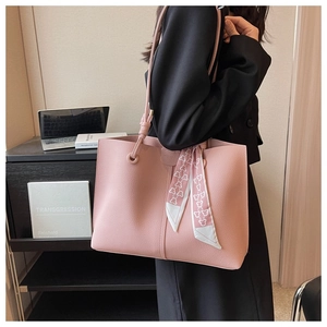Pink tote bag with lychee texture and silk scarf accessory shown in office setting