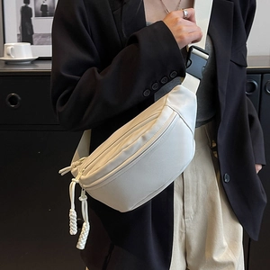 Minimalist cream canvas crescent crossbody bag with woven pullers and adjustable strap