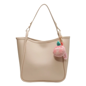 Large beige faux leather tote bag with wavy edge design and pink peach plush charm