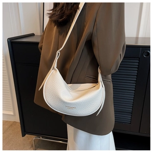 Detail of off-white leather crescent bag with adjustable strap and golden logo logo