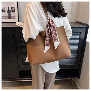 Detail of brown litchi pattern leather tote bag with a decorative printed silk scarf