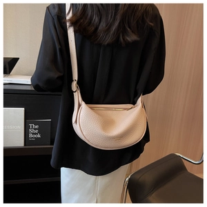 Detailed view of light pink lychee texture leather crescent bag with gold metal zipper