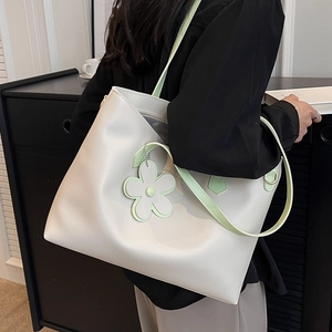 Minimalist large capacity tote bag in cream white and green with daisy charm on a model