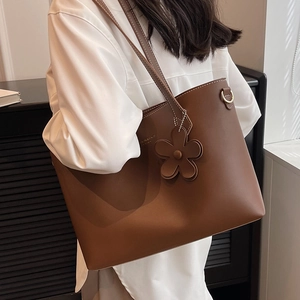 Brown leather large tote bag with contrast stitching and floral charm for women