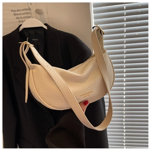 Close-up of cream hobo bag showing lychee grain leather texture and gold hardware