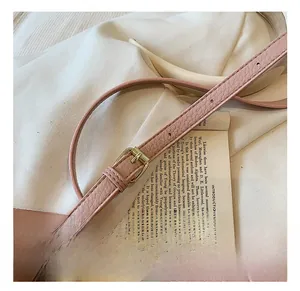 Detailed view of pink pebble grain leather strap with adjustable golden metal buckle