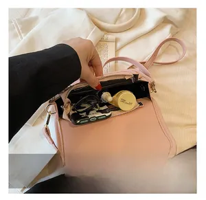 Detail view of pink crossbody bag interior capacity with sunglasses and cosmetics