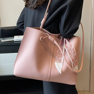 Pink large-capacity tote bag in lychee texture with bear print scarf on a black suit model
