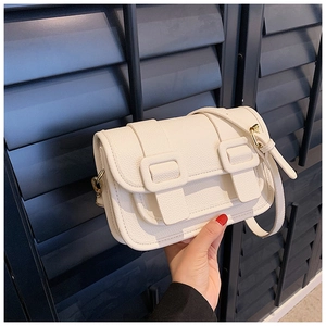Detail of cream white leather crossbody bag with gold twist lock and textured finish