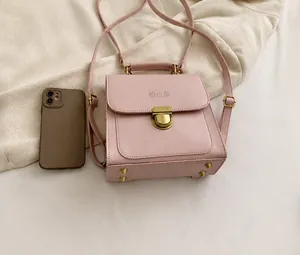Rosa PU-Leder Handtasche im Größenvergleich mit Handy und goldenem Steckverschluss-Detail