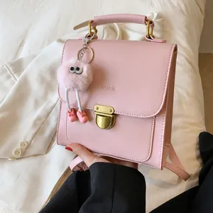 Detailaufnahme der rosa Kunstledertasche mit Goldschnalle und Plüschanhänger