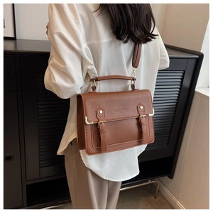 Bolso bandolera de cuero PU marrón vintage llevado por una modelo en una habitación mínima