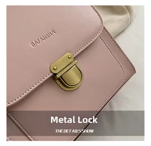 Detail eines rosa Lederrucksacks mit goldenem Vintage-Verschluss und Logo-Prägung