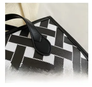 Close-up of durable cross-grain leather texture and precise stitching on the tote bag