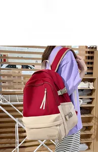 Vue latérale du grand sac à dos rouge et beige avec boucles sur un mannequin