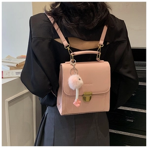 Rosa Rucksack aus PU-Leder mit Vintage-Metallschnalle und Plüschball an einem Model