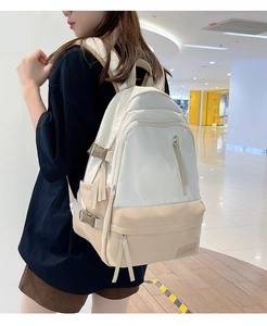 Détail d'un sac à dos grande capacité avec écusson en cuir et plusieurs poches