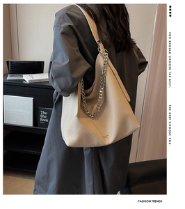 Dettaglio borsa a tracolla in pelle martellata beige con catena argentata