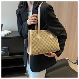 Detail of a large beige checkered tote bag with long shoulder straps for daily commuting