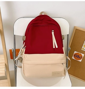 Détail du sac à dos en toile rouge et beige avec boucles latérales et patch LIBANO