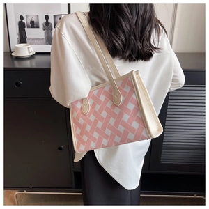 Model wearing a large pink and white tweed tote bag with stylish cream leather trim