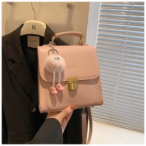 Detailansicht der rosa PU-Leder Handtasche mit Goldschnalle und Plüschtier-Anhänger