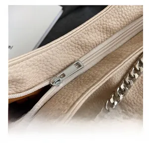 Dettaglio borsa in pelle beige con grana litchi e catena metallica argentata lucida