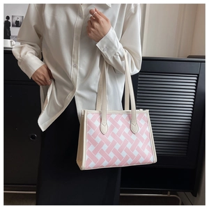 Detail view of the pink and white woven tote bag with premium cream shoulder straps