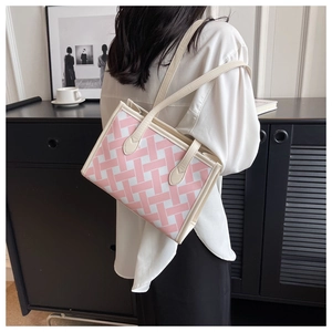 Fashionable pink checkered tote bag shown on model with white leather trim and straps