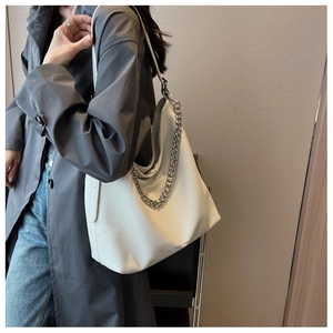 Dettaglio della borsa tote bianca in pelle martellata con catena in metallo argento