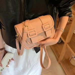 Pink lychee texture crossbody bag with gold hardware and double buckle flap design