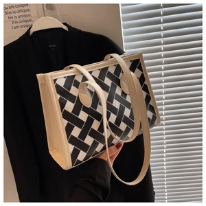Close-up of the black and white geometric pattern and off-white handle of the tote bag