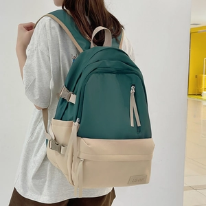 Sac à dos grande capacité bicolore vert et beige en nylon imperméable porté par un mannequin