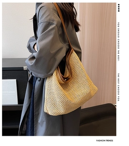 Close-up of woven hollow crochet texture and brown leather strap on beige straw tote bag