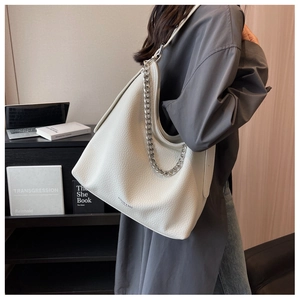 Dettaglio della borsa tote in pelle bianca con catena d'argento e logo del marchio
