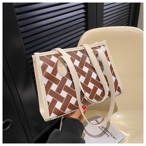 Detail of woven geometric pattern and long shoulder straps on a stylish tote bag