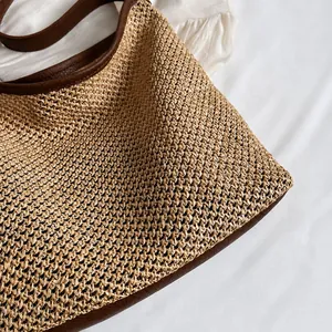Detail shot of the tight woven raffia texture and premium brown leather trim on the bag