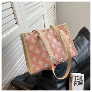 Detail of pink and white woven tote bag with premium leather handles and texture