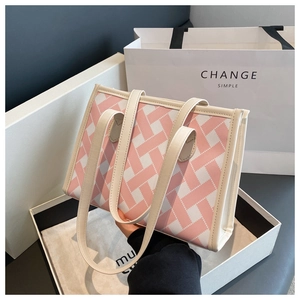 Close-up of pink and white woven texture on a large tote bag with leather trim