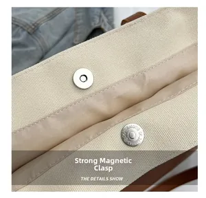 Detail of the strong magnetic clasp on the large canvas tote bag showing internal lining