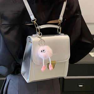 Kleiner silberner Metall-Rucksack für Damen mit einem süßen rosa Plüsch-Anhänger