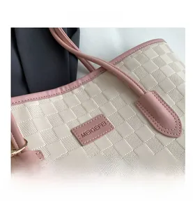 Close-up of pink and cream woven checkerboard texture with leather logo on tote bag