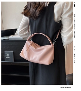 Close-up of pink PU leather shoulder bag with silver metal hooks and branded logo details
