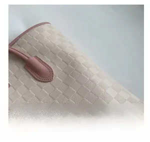 Macro detail of the checkered texture and reinforced stitching on the pink tote bag