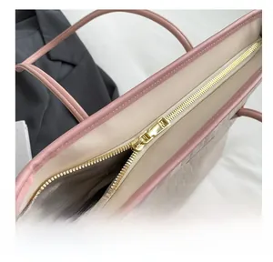 Detail view of smooth golden zipper closure and herringbone fabric lining on tote bag